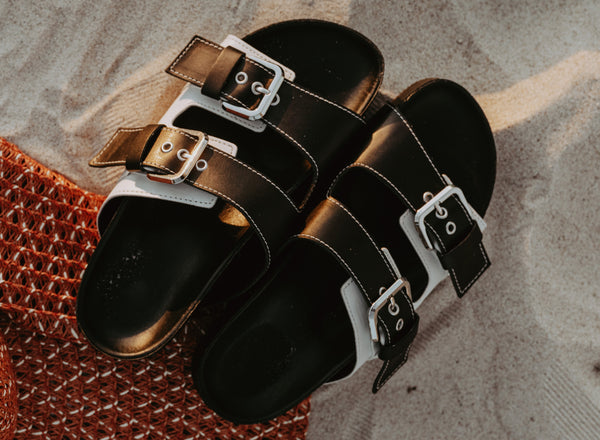 black men's sandals with buckles on sand