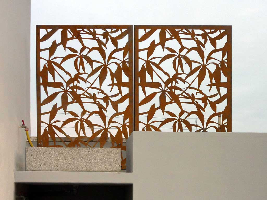 Raw CorTen steel screens with laser cut Schefflera design fixed to the parapet