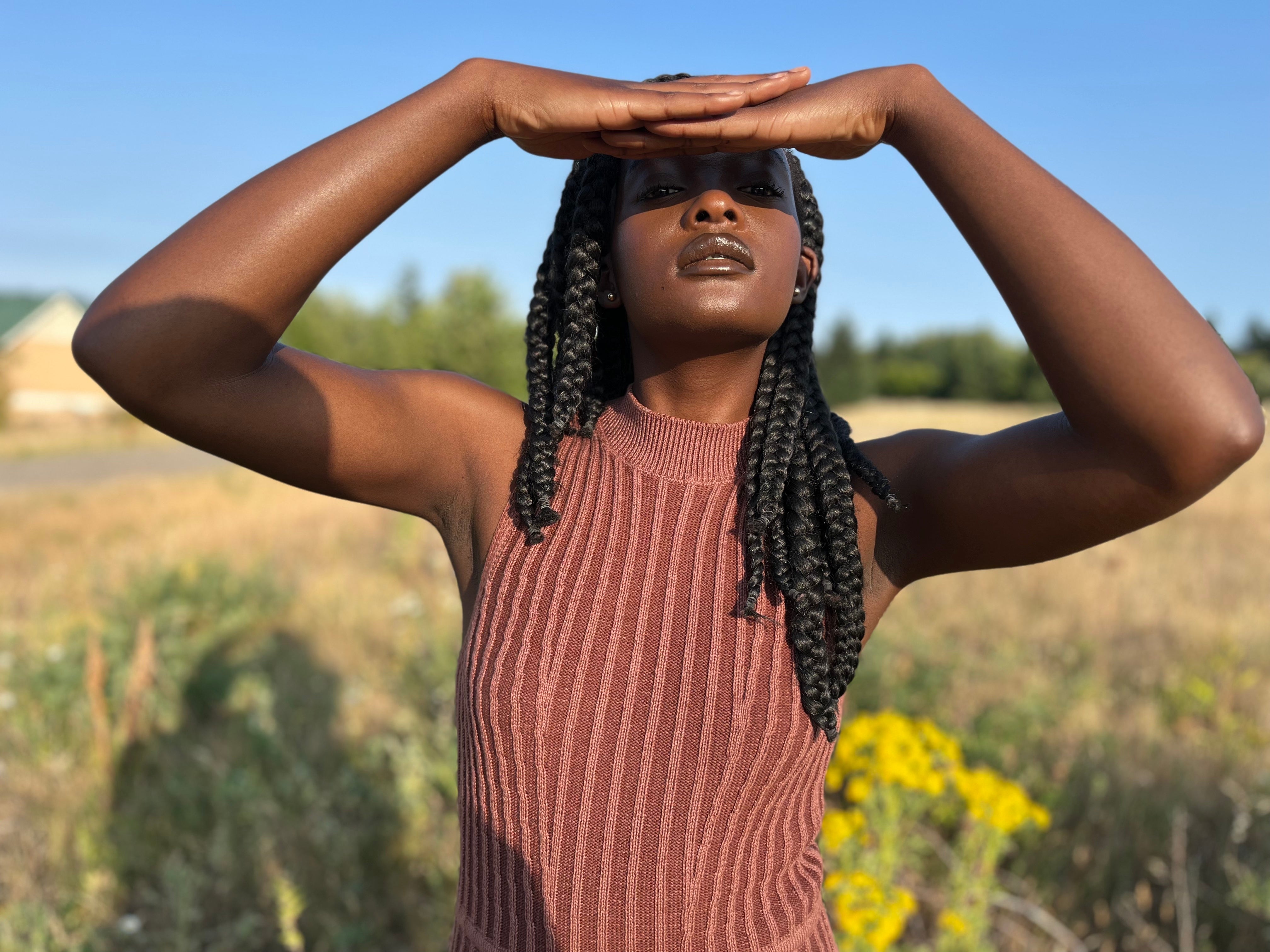 Naomi Likayi in a Soluna Collective Two Tone Knit Dress. Sunshine and a field.