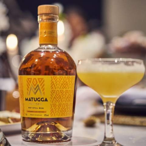 Bottle of Matugga rum, alongside a rum cocktail