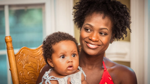 Afrocenchix postpartum hair loss image of black woman holding a baby
