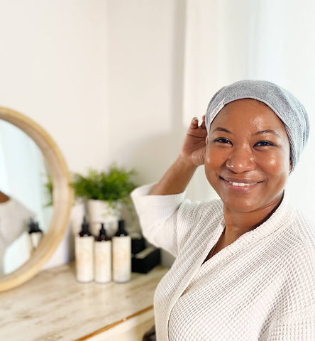 Black woman smiling with Afrocenchix microfibre towel and white robe on