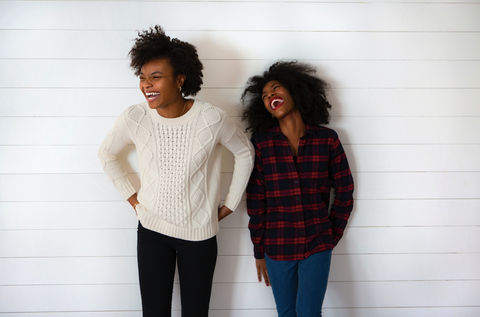two black women with natural hair laughing