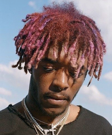 Black man looking down with pink coloured dreadlocks