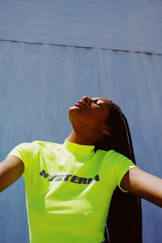 Black woman with box braids looking up in the sunshine