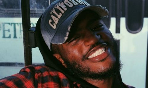 smiling black man with cap and beard