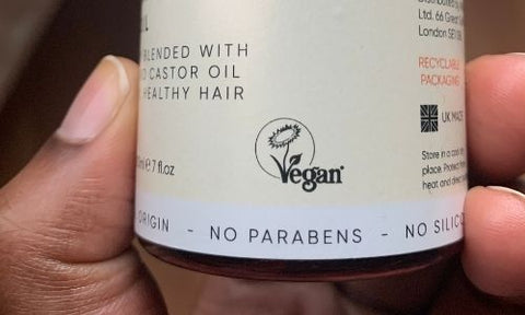 What’s the Difference Between Vegan & Cruelty-free Beauty Products?close up of an Afrocenchix bottle being held showing the Vegan Logo