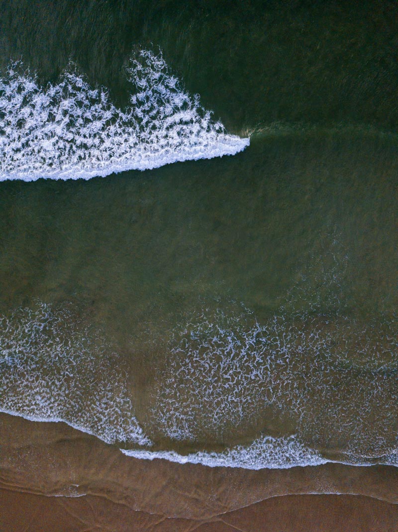 Aerial photograph of turquoise wave breaking in Tamarindo Costa Rica. Fine art aerial photography print Photographed by Kristen M. Brown, Samba to the Sea for The Sunset Shop.