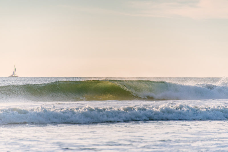 Backlit turquoise wave breaking in Tamarindo Costa Rica. Photographed by Kristen M. Brown, Samba to the Sea for The Sunset Shop.