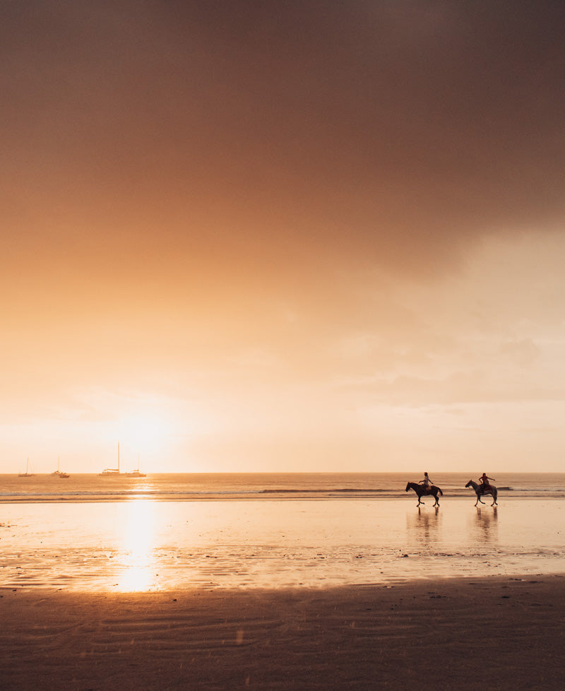 Horseback riding on the beach in Costa Rica at sunset. Photographed by Kristen M. Brown, Samba to the Sea for The Sunset Shop.