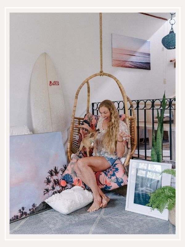 Destination Costa Rica photographer Kristen M. Brown and her Chihuahua Gidget at home with her sunset and beach photography prints. Boho surf shack in Tamarindo, Costa Rica. Samba to the Sea for The Sunset Shop.