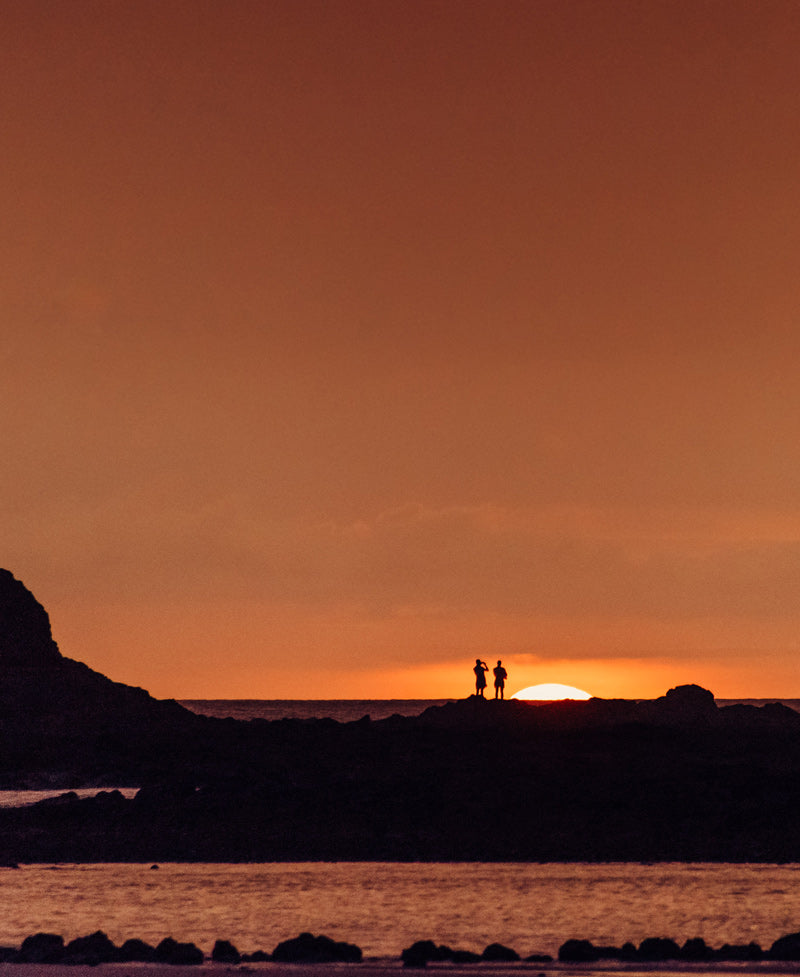 Couple watching sunset in Tamarindo Costa Rica. Photographed by Kristen M. Brown, Samba to the Sea for The Sunset Shop.