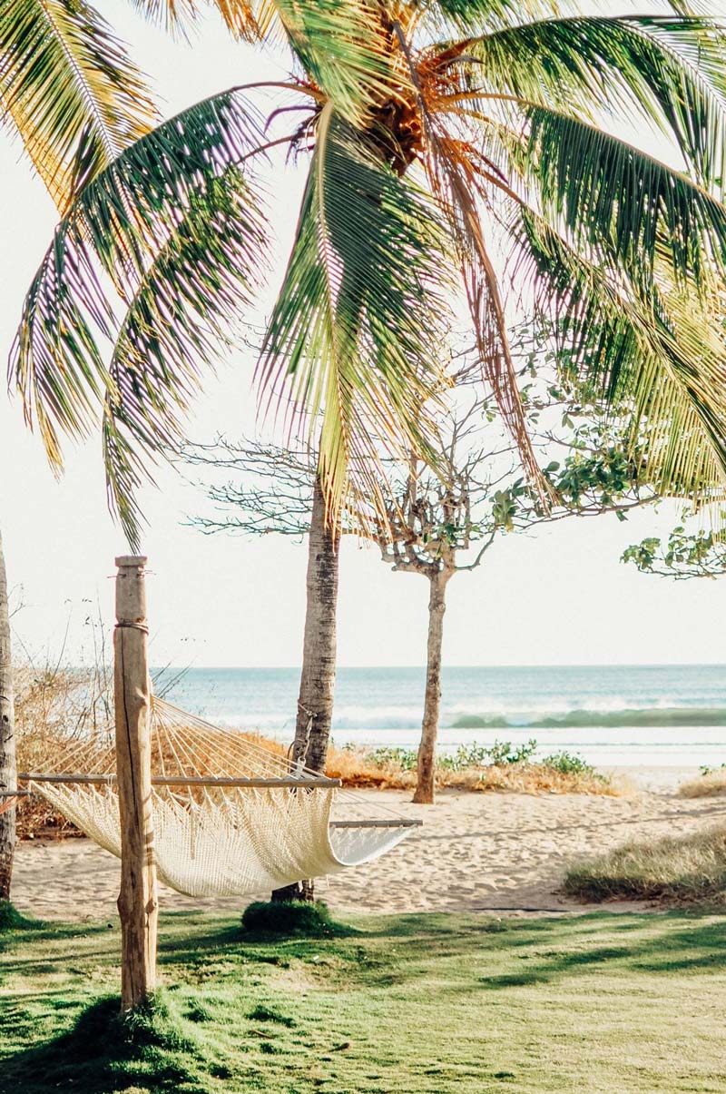 Hammock and palm trees at the beach in Playa Grande Costa Rica. Photographed by Kristen M. Brown, Samba to the Sea for The Sunset Shop.