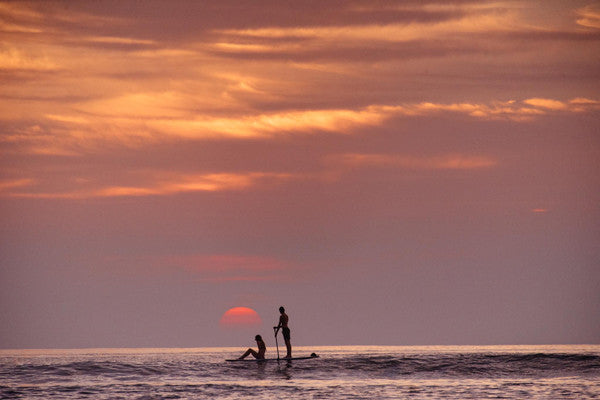 SUP paddling during sunset in Tamarindo, Costa Rica. Photographed by Kristen M. Brown, Samba to the Sea at The Sunset Shop.