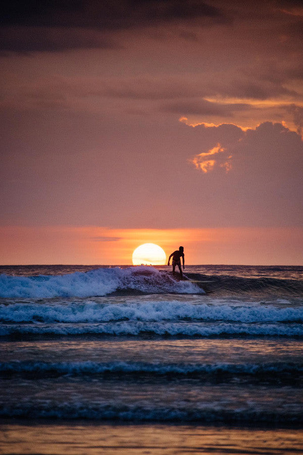 Surfing in Tamarindo, Costa Rica during sunset. Photographed by Kristen M. Brown, Samba to the Sea for The Sunset Shop.