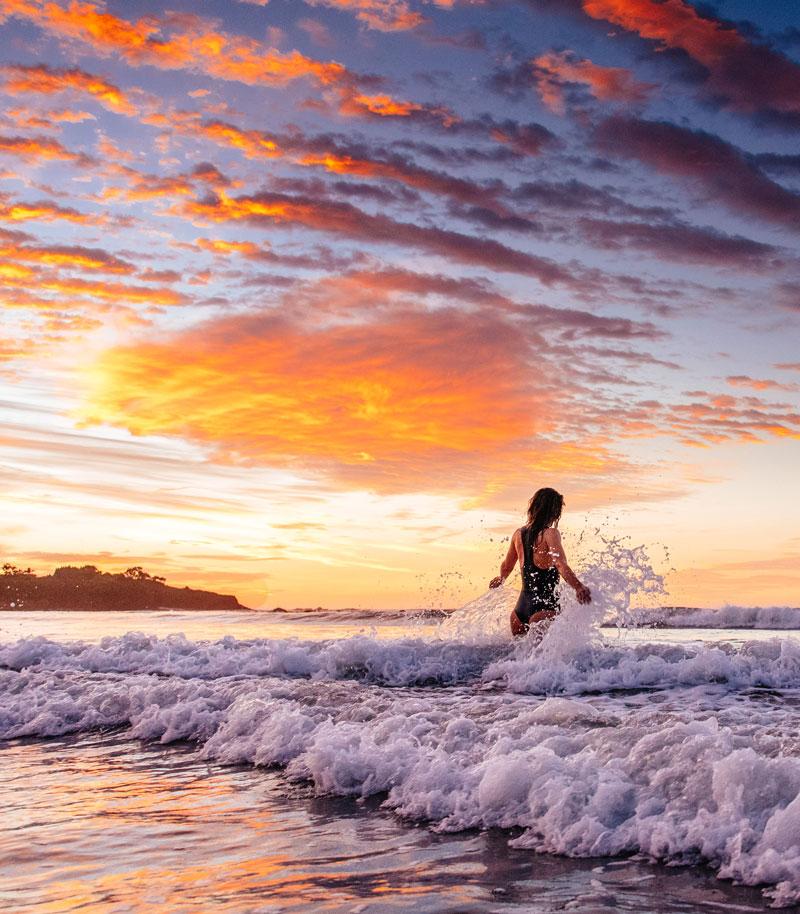 Surfer girl playing in the waves in Costa Rica. Photographed by Kristen M. Brown, Samba to the Sea for The Sunset Shop.