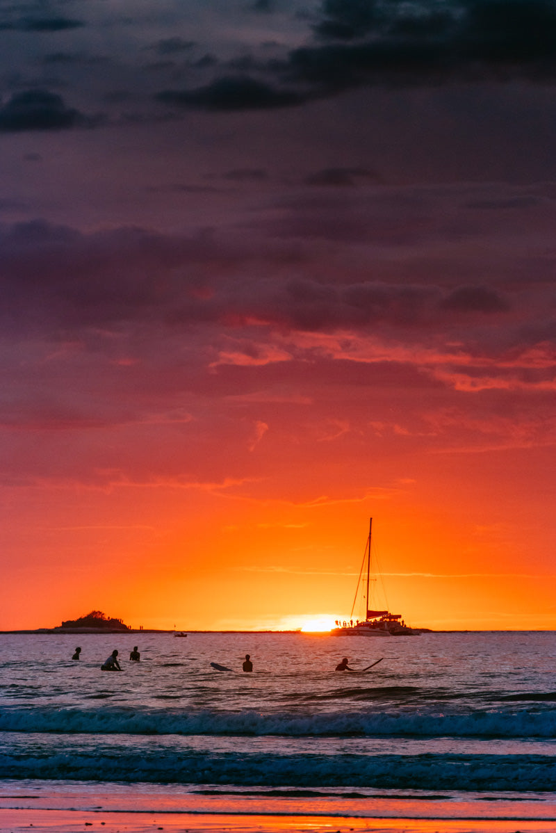 Surfers during sunset in Tamarindo Costa Rica. Photographed by Kristen M. Brown, Samba to the Sea for The Sunset Shop.