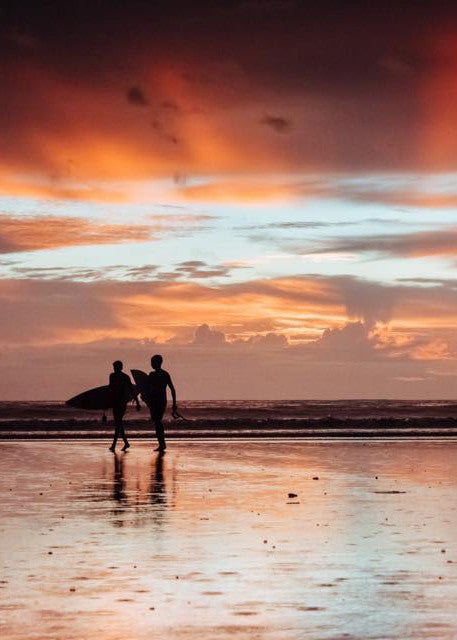 Surfers walking on the beach during sunset over the Pacific Ocean in Tamarindo Costa Rica. Photographed by Kristen M. Brown Samba to the Sea.
