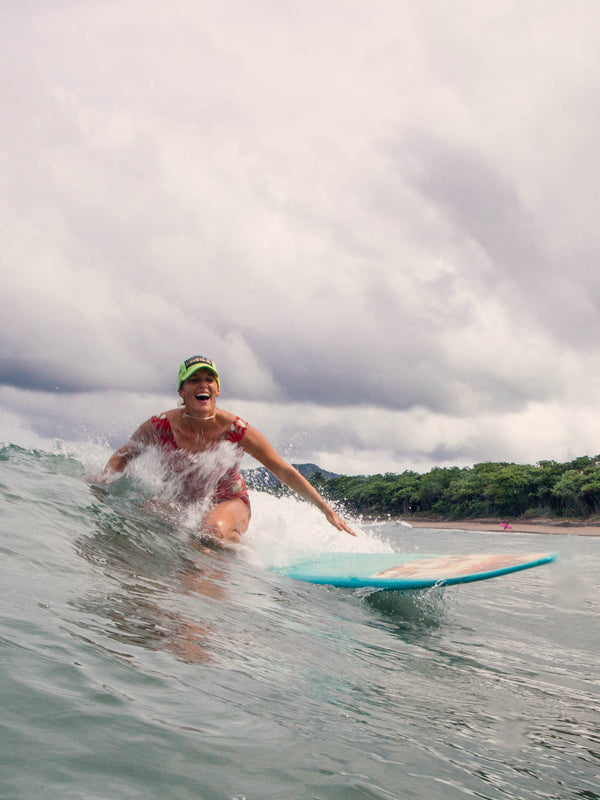 Surfer girl laughing while surfing in Tamarindo, Costa Rica. Kristen M. Brown, Samba to the Sea.