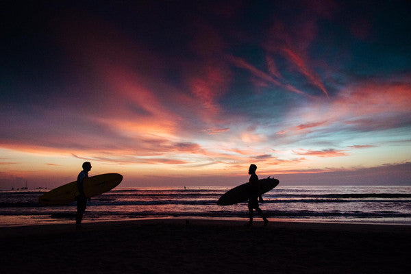 Surfers on the beach at sunset in Costa Rica. Photographed by Kristen M. Brown, Samba to the Sea at The Sunset Shop.