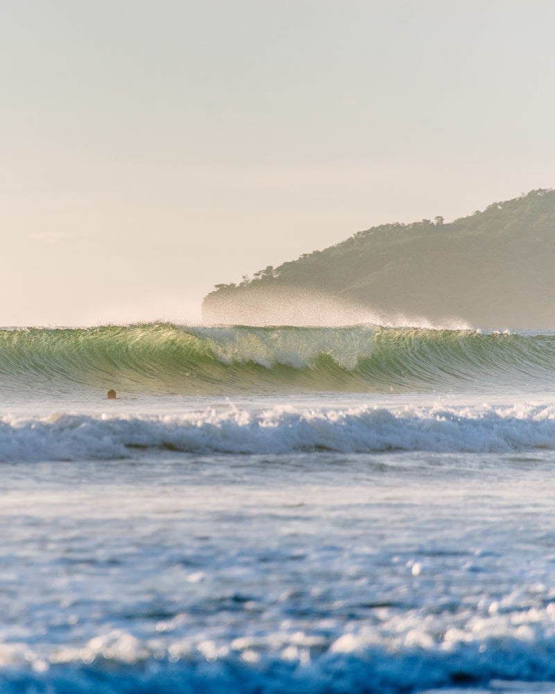 Backlit turquoise wave breaking in Tamarindo Costa Rica. Photographed by Kristen M. Brown, Samba to the Sea for The Sunset Shop.