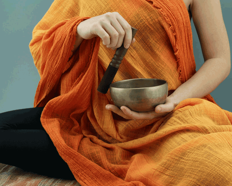 Tibetan monk playing a singing bowl