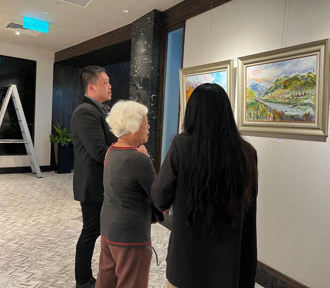 Three persons looking at a painting