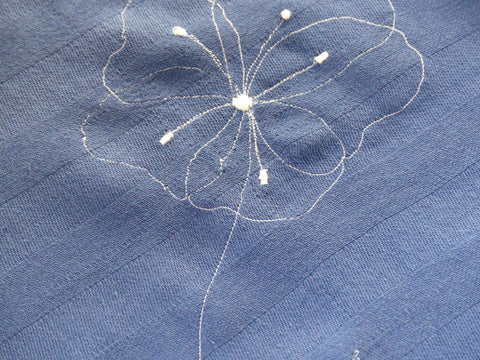 a flower embroidered to a tea towel