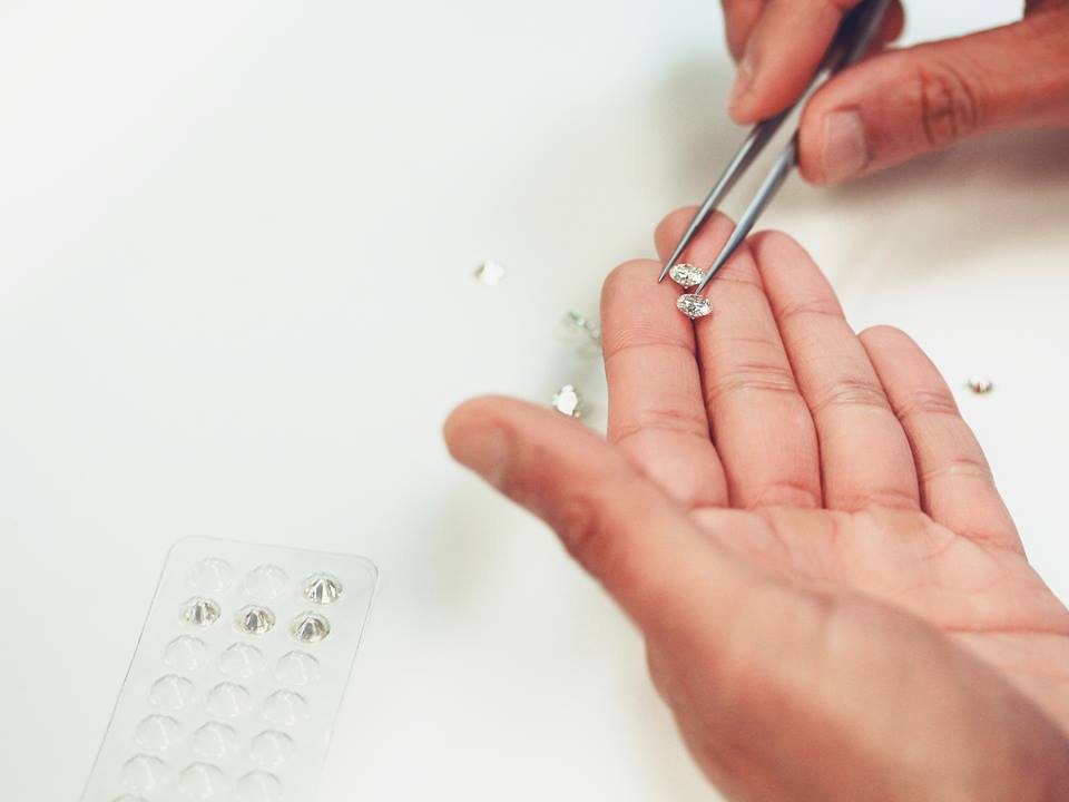 person selecting faceted moissanite gemstones