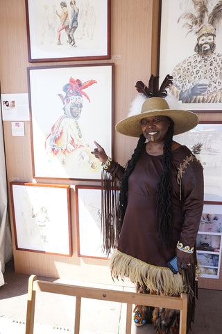 Big Queen Rukiya Brown poses with a portrait of her by Annie Moran