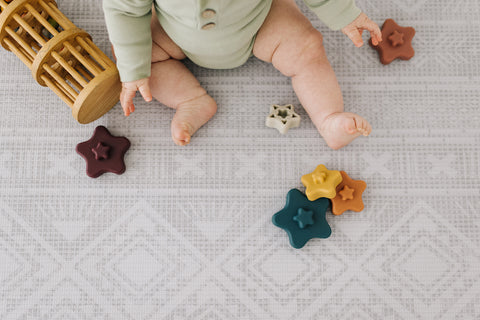 baby with toys on play mat