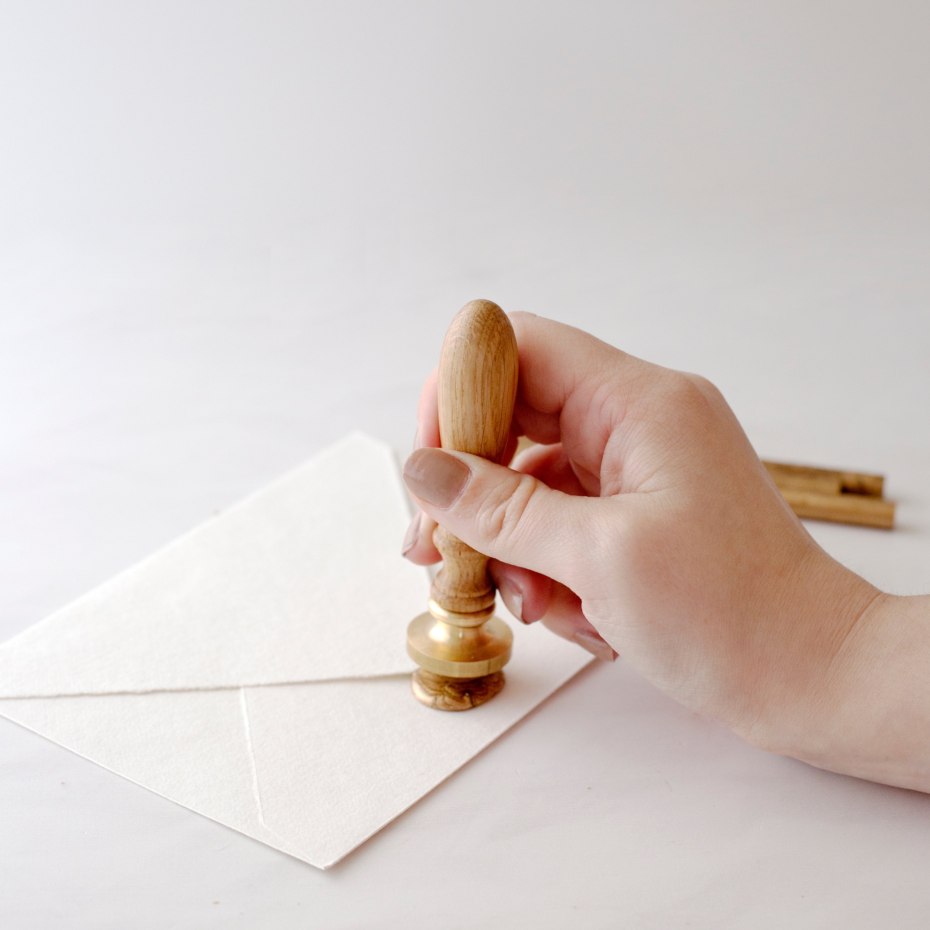 Pressing Wax Seal Stamp Into Gold Sealing Wax On Back Of Envelope | How To Use A Wax Seal Stamp With A Glue Gun | Heirloom Seals