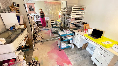Miss Annie's home workshop includes a desk for shipping, a baker's rack for storage, and a glowforge laser engraver in front of mirrored closet doors.