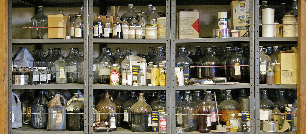 Vintage shelving full of dusty bottles. Ingredients that have gone into making the best shoe polish for 90 years.