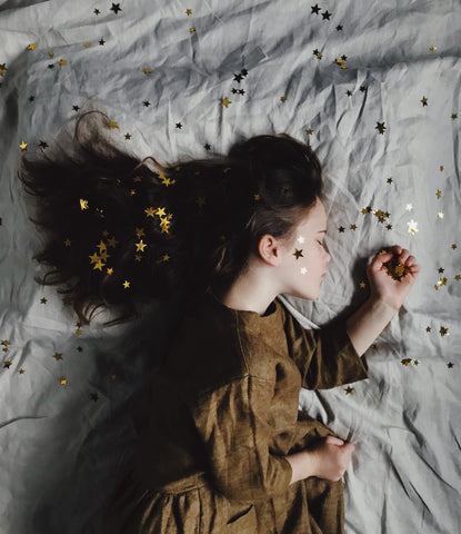 side profile of child with stars on hair and face by Annie Spratt on Unsplash.com