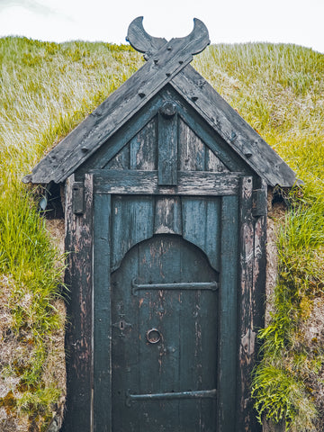 green door on earthen mound home by Antonio Morillas on Unsplash.com