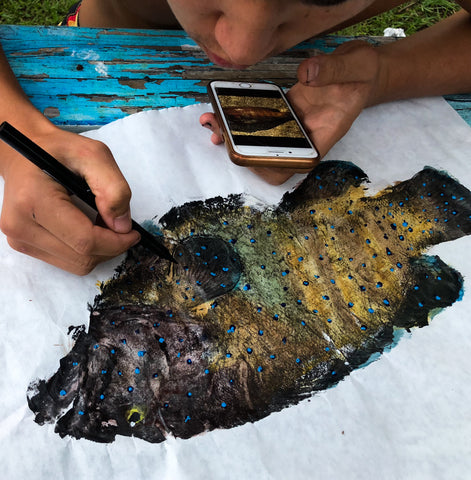 The Hawaiian artist Akira adds a final touch to his Gyotaku print