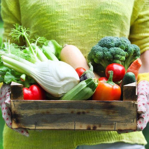 Lady holding wooden tray of fresh produce