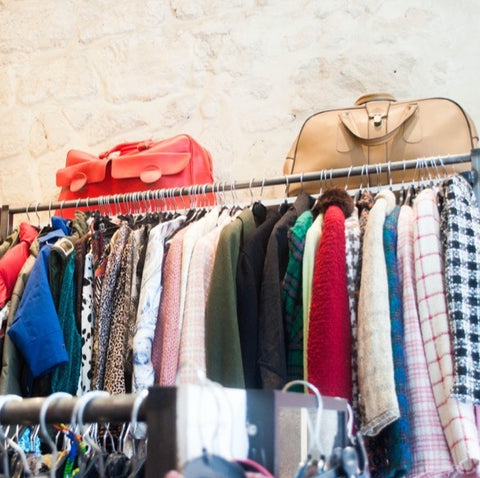 Charity shop rails with clothes and handbags