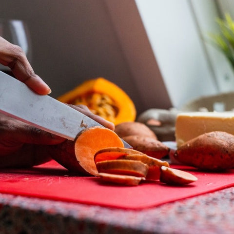 Chopping sweet potato on board