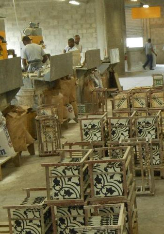 Cement tiles are placed on racks as they come off the line