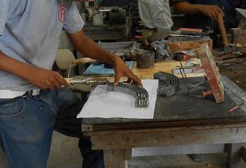 A cement tile mold is being worked on and checked against a pattern