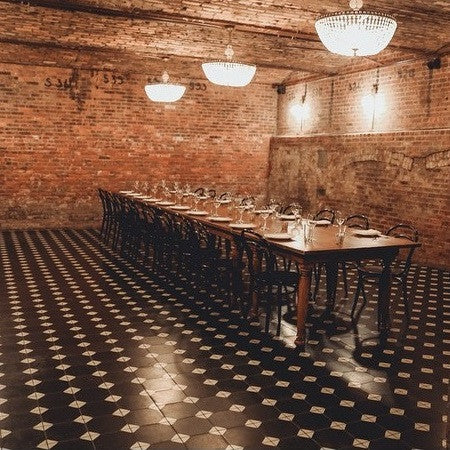 The Wythe Hotel in Brooklyn, NY creates a classic look for their banquet hall using black and white with an octagon and dot cement tile floor pattern