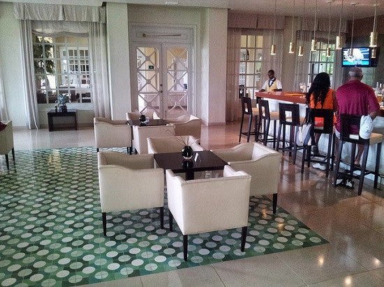 A central white circle surrounded by different shades of green is the perfect pattern and color choice for the cement tile floor at the club house dinning room and bar of this golf course.