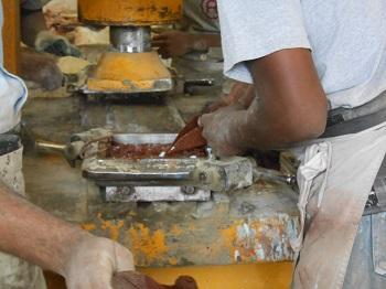 Colored cement being poured into the sections of a cement tile mold