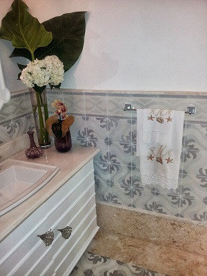 Cement tiles are used on the wall and floor in a powder room