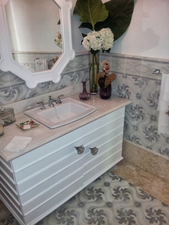 Soft colors mute a cement tile pattern in this powder room