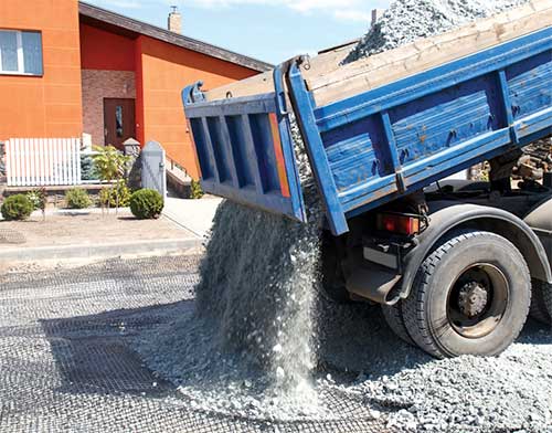 Dump Truck dumping gravel on Geogrid