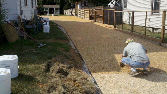 Worker installing stone on a resin-bond driveway