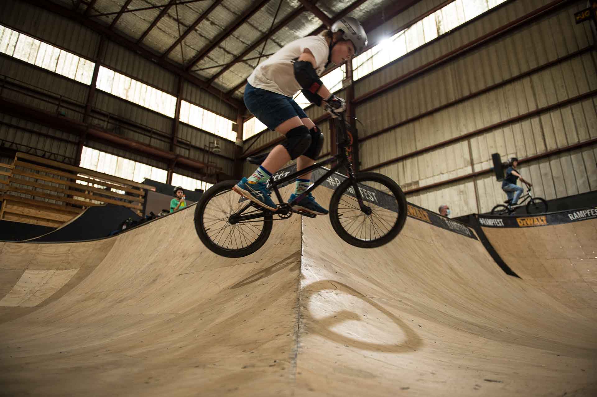 BMX student Zach Hutton jumps the hip in the bowl at Rampfest Indoor Skatepark